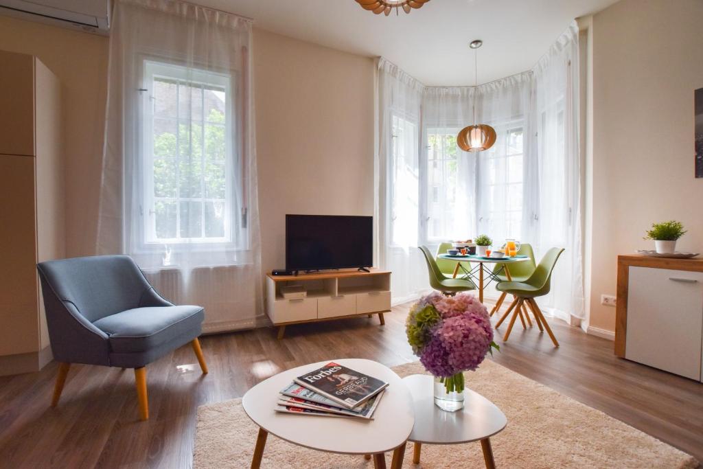 布达佩斯Christine Apartment close to the Buda Castle的客厅配有蓝色椅子和电视
