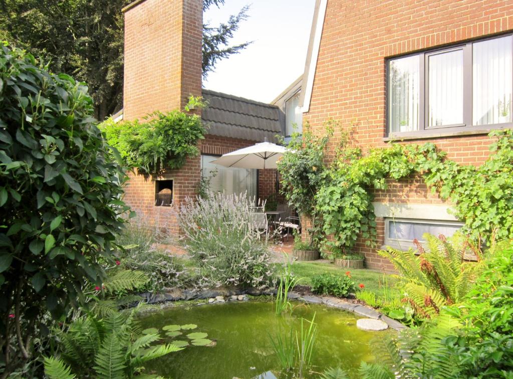 蒙斯Les Chambourlettes的一座花园,在一座建筑前设有一个池塘
