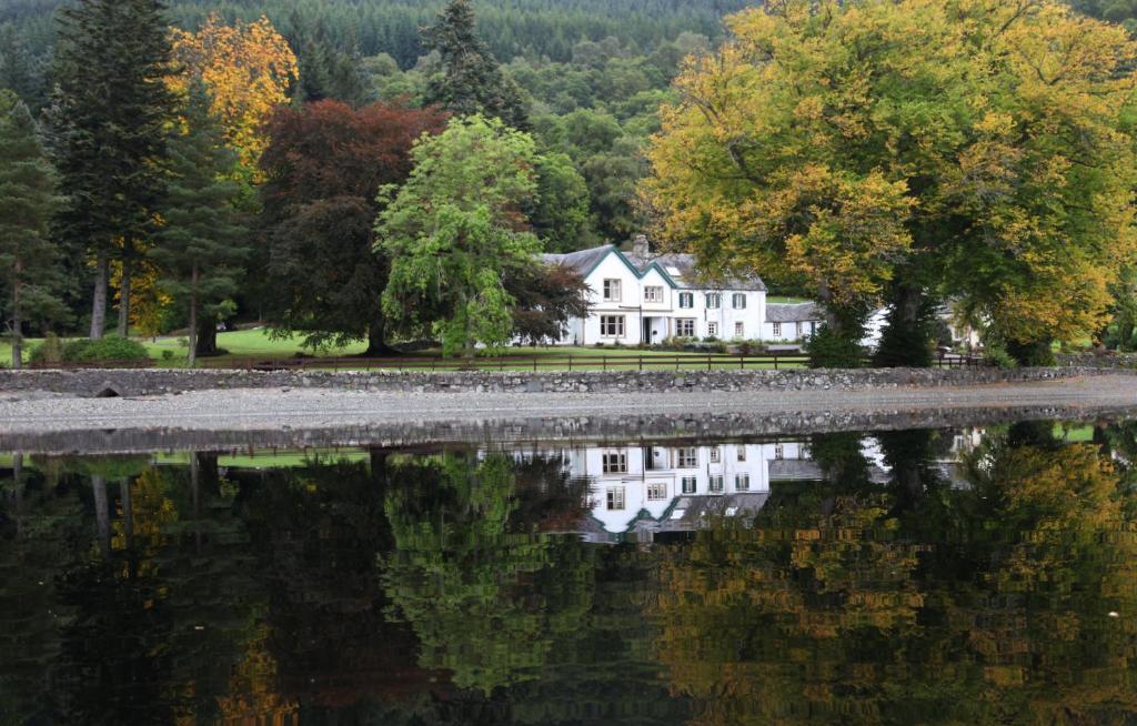 阿伯福伊尔Altskeith Country House的湖水中反映的房子