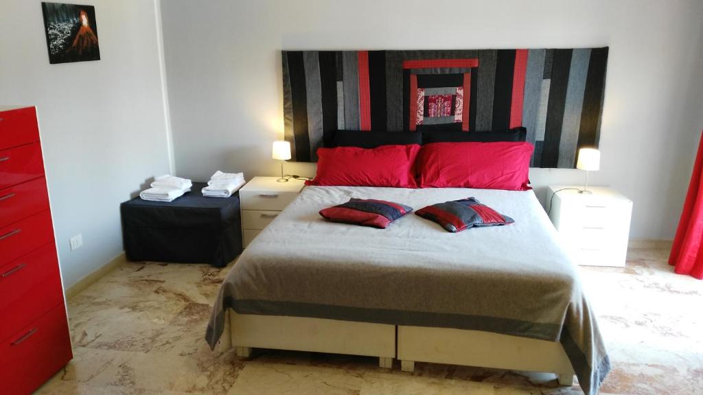 扎费拉纳-埃特内阿卡托林德拉玛住宿加早餐旅馆的一间卧室配有一张带红色枕头的大床