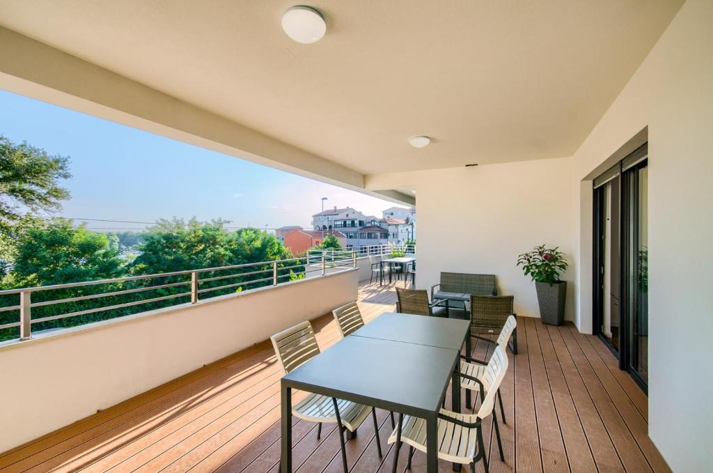 普拉Rooms K&T sea side luxury的设有一个配有桌椅并享有美景的阳台。