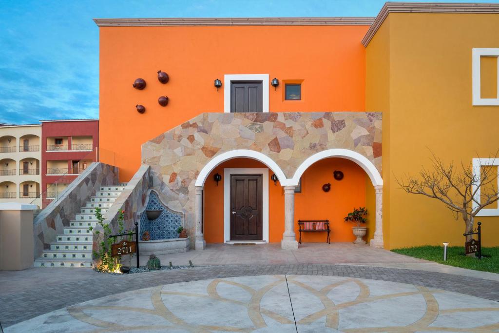 卡波圣卢卡斯恩坎塔达庄园别墅的一座橙色的建筑,前面有楼梯