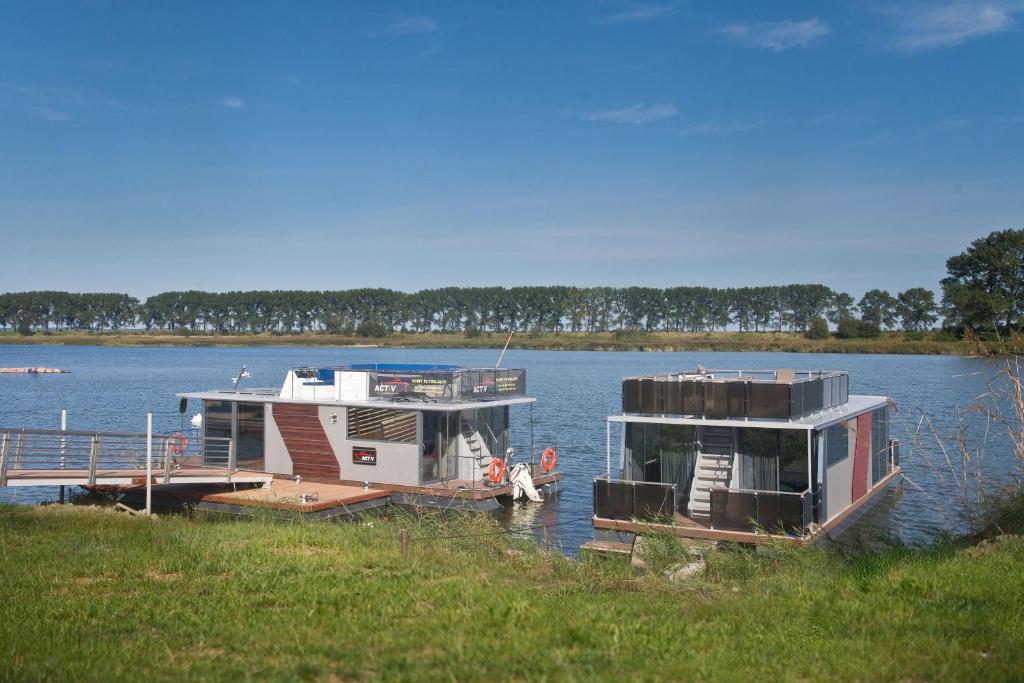 BłotnikHouseboat的两艘船停靠在湖上的一个码头