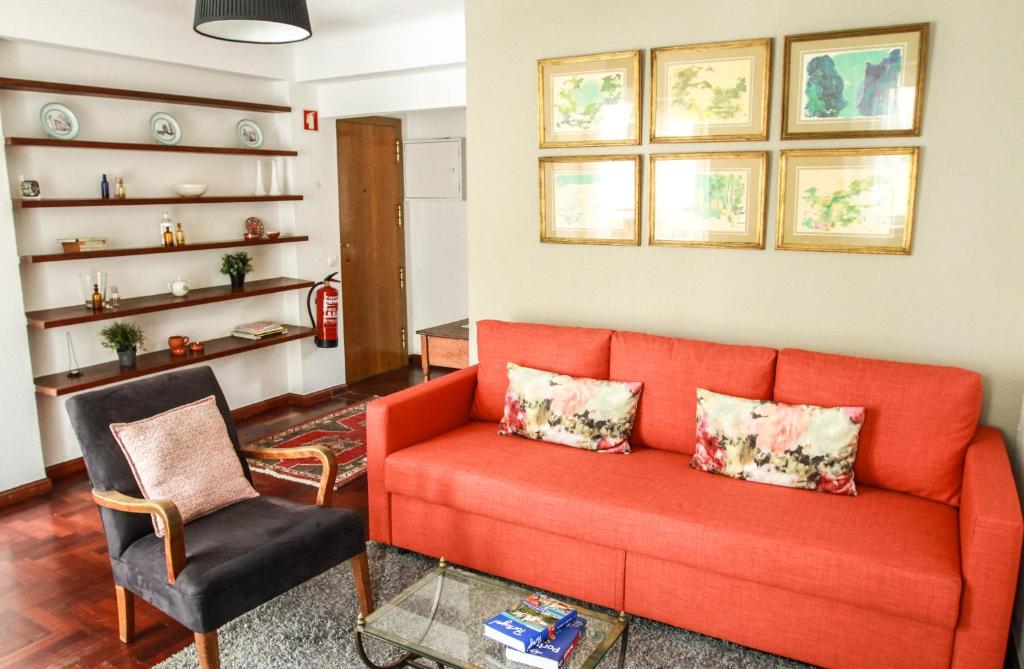 里斯本Cozy and Spacious apartment in Graça, Lisbon的客厅配有橙色沙发和椅子