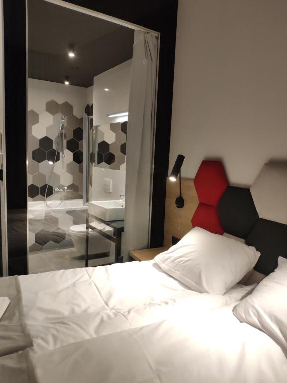 比托姆H33 Apartamenty的一间带一张床的卧室和一间带镜子的浴室