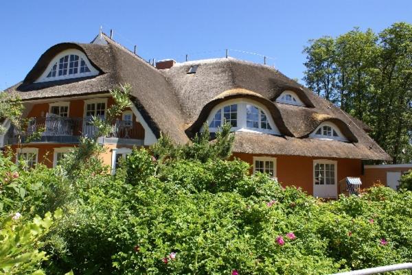 普雷罗Hotel Residenz Rennhack的茅草屋顶和灌木的房子