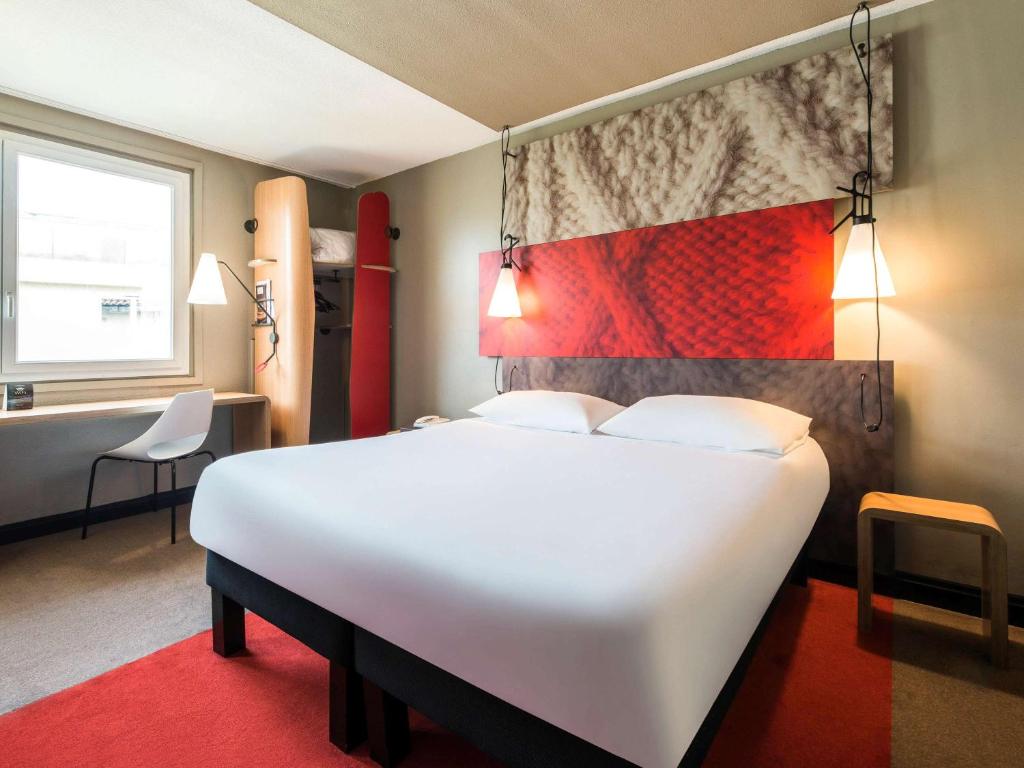 科涅克Hôtel Ibis Cognac Centre的卧室配有一张白色大床和一张书桌