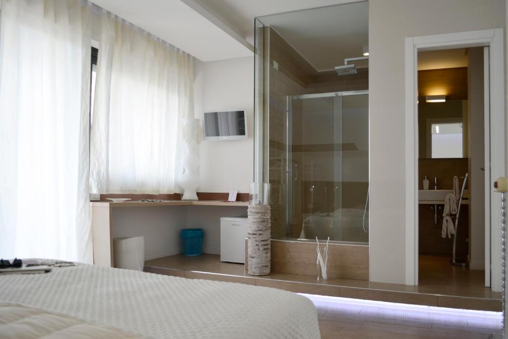 滨海波利尼亚诺B&B Dimora Silvestri的一间带玻璃淋浴间和一张床的卧室