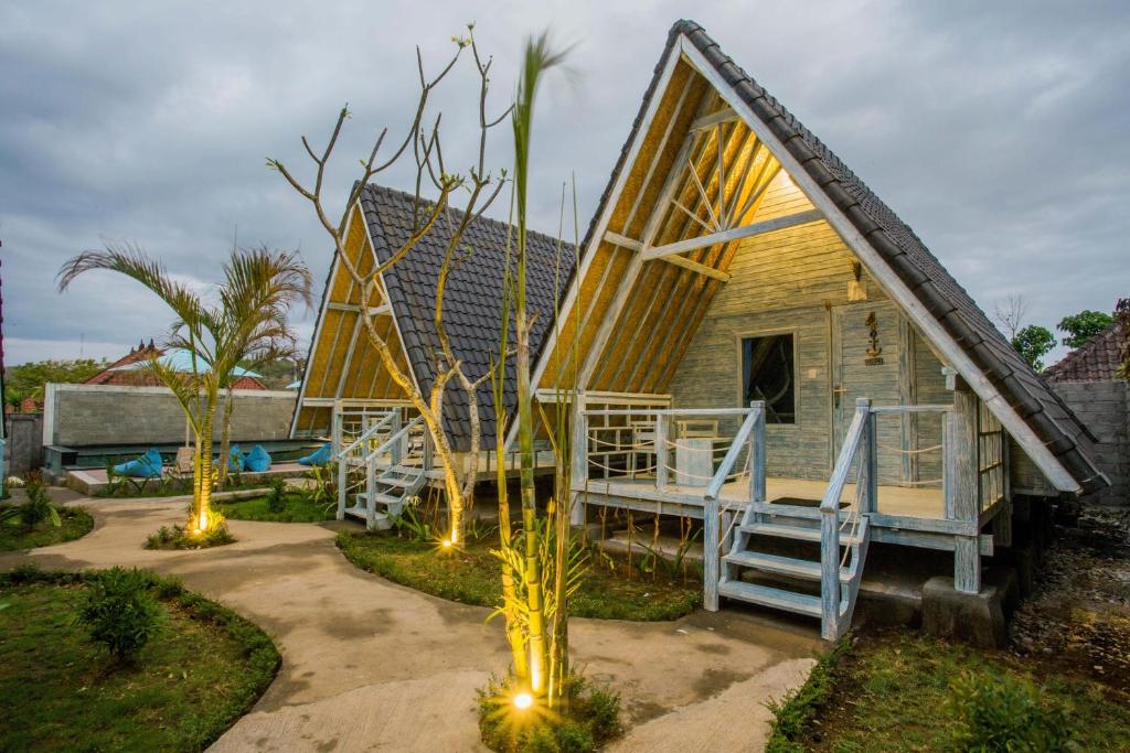 蓝梦岛D'Yuki Huts Lembongan的一个小房子,设有门廊和甲板