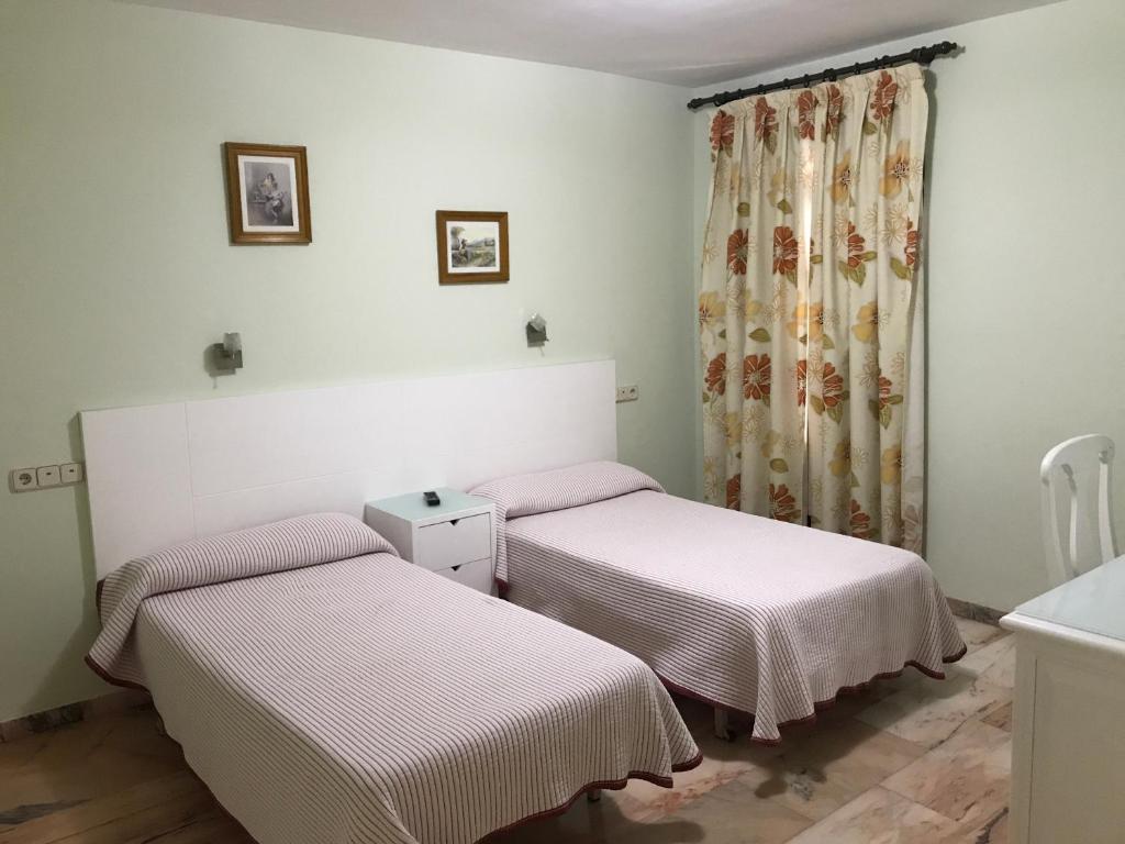 阿尔卡拉拉雷亚尔里奥德奥罗旅馆的带窗户的客房内设有两张单人床。