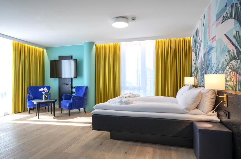 奥斯陆Thon Hotel Storo的一间卧室配有大床和黄色窗帘