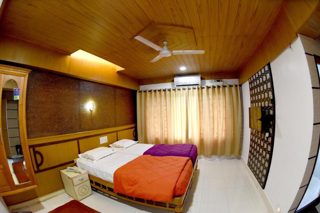 乌杜皮Hotel Sharada International的一间卧室配有一张床和吊扇