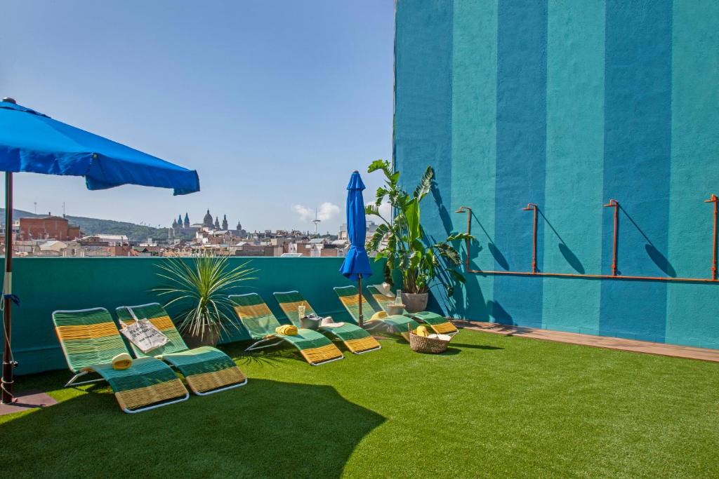 巴塞罗那天鹅绒时尚基础酒店的屋顶上带草坪椅和遮阳伞的天井