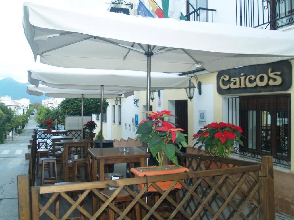 普拉多德尔雷卡伊科酒店的室外餐厅设有桌椅和遮阳伞。