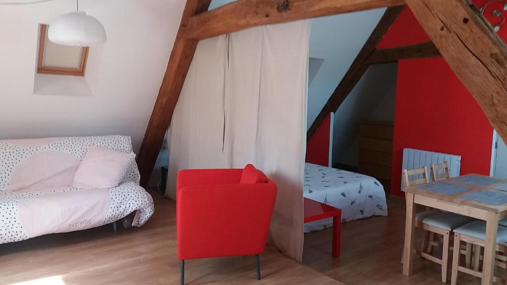 莱桑德利Le charme du château的一间卧室配有红色椅子、一张床和一张桌子