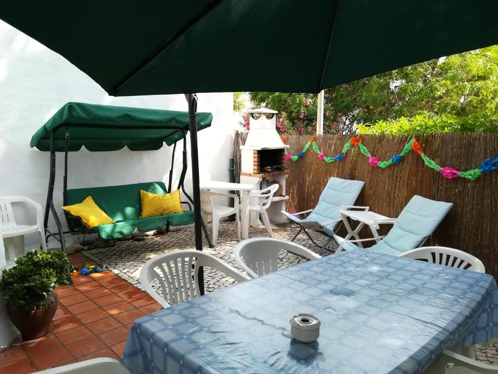 拉戈斯Villa Brito的庭院配有桌椅和遮阳伞。