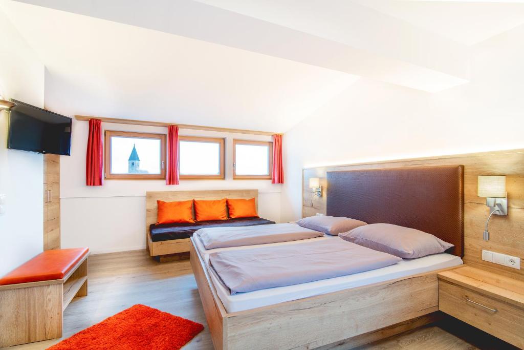 维皮泰诺Hotel Sonnenheim的一间卧室配有两张带橙色枕头的床