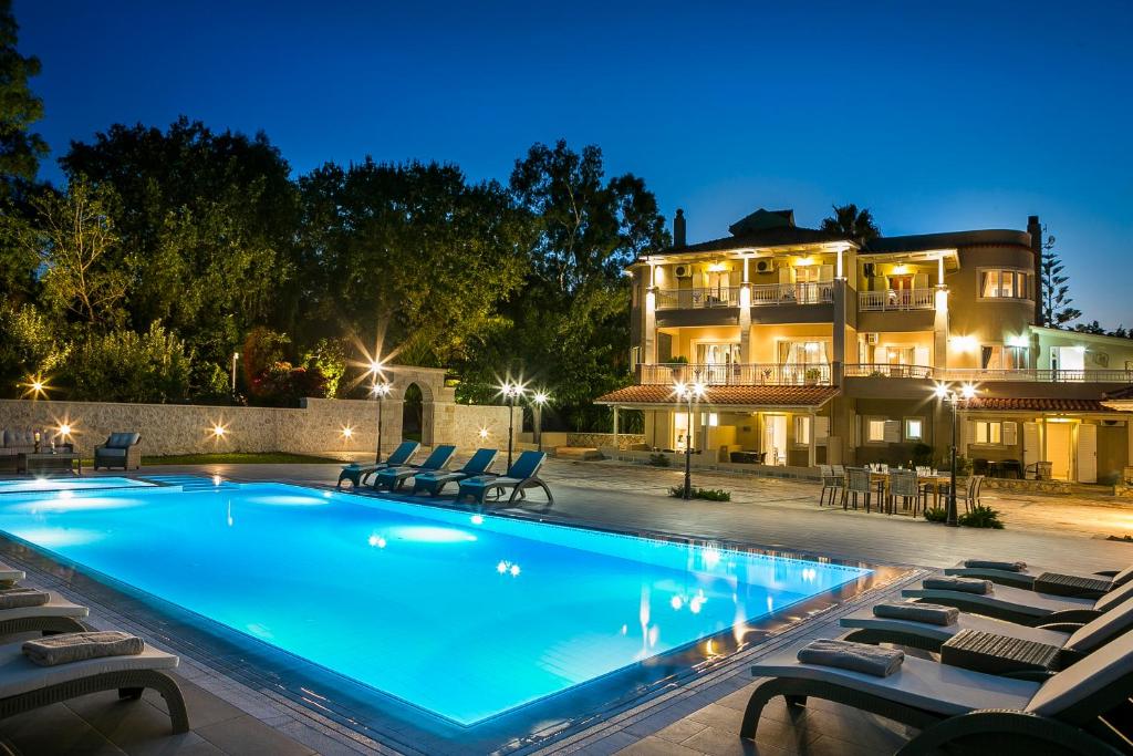斯巴达Hidden Gem Estate - Superior luxury villa large private pool stunning sea & mountain views 5 acres of lush gardens World class accommodation的夜间在房子前面的游泳池