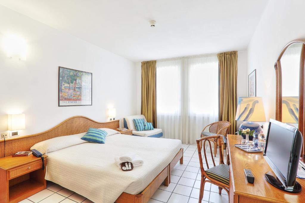 马西亚娜马里纳游艇俱乐部酒店的酒店客房配有一张床、一张书桌和一台电视。