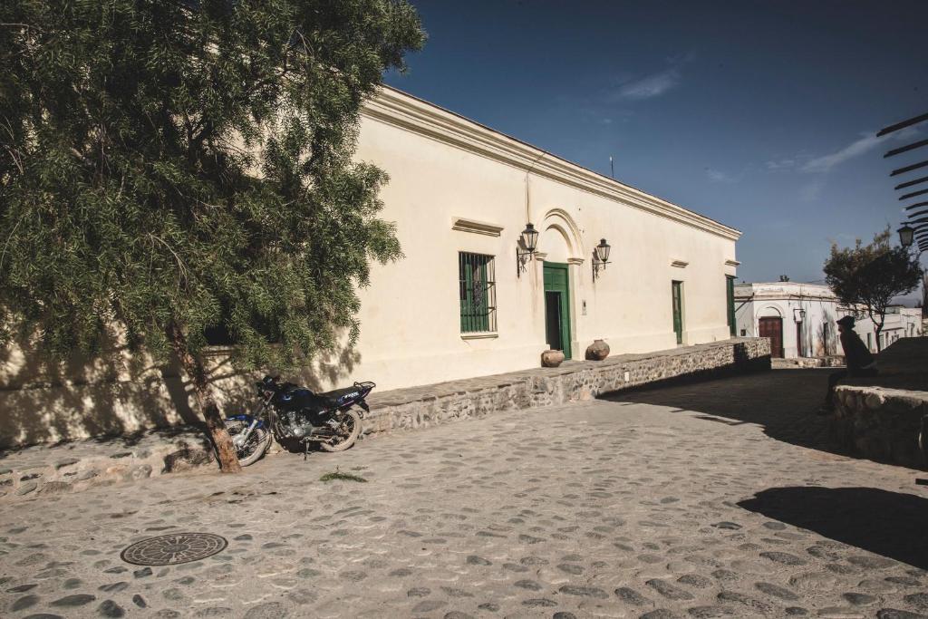 卡奇Casa del Tejedor的停在白色建筑前的摩托车