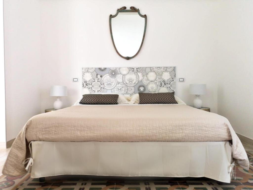 莱切Eccelsoleccese的卧室配有一张大床,墙上装有镜子