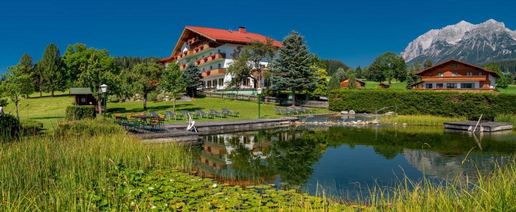 拉姆绍达赫斯坦凯尔胡伯霍夫乡村酒店的山前有湖泊的酒店