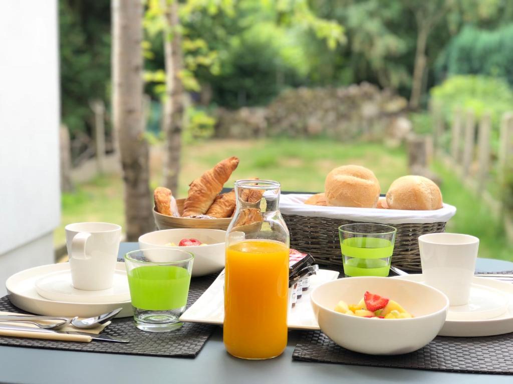 梅赫伦花园55住宿加早餐旅馆的包括一篮食物和橙汁的早餐桌