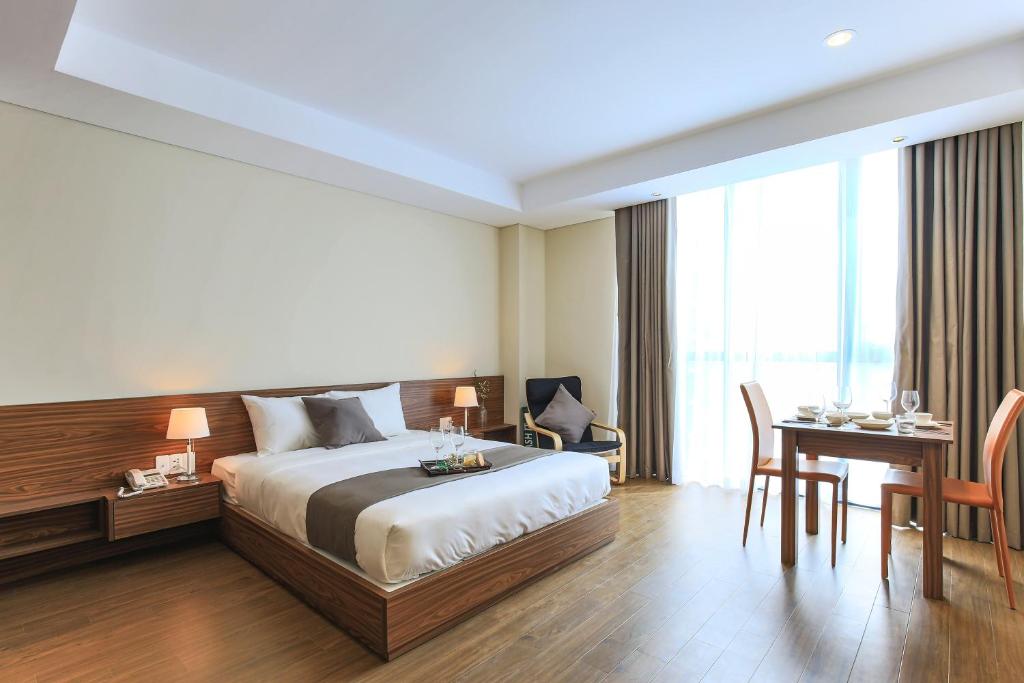 胡志明市极光服务式公寓的配有一张床、一张桌子和一张桌子的酒店客房