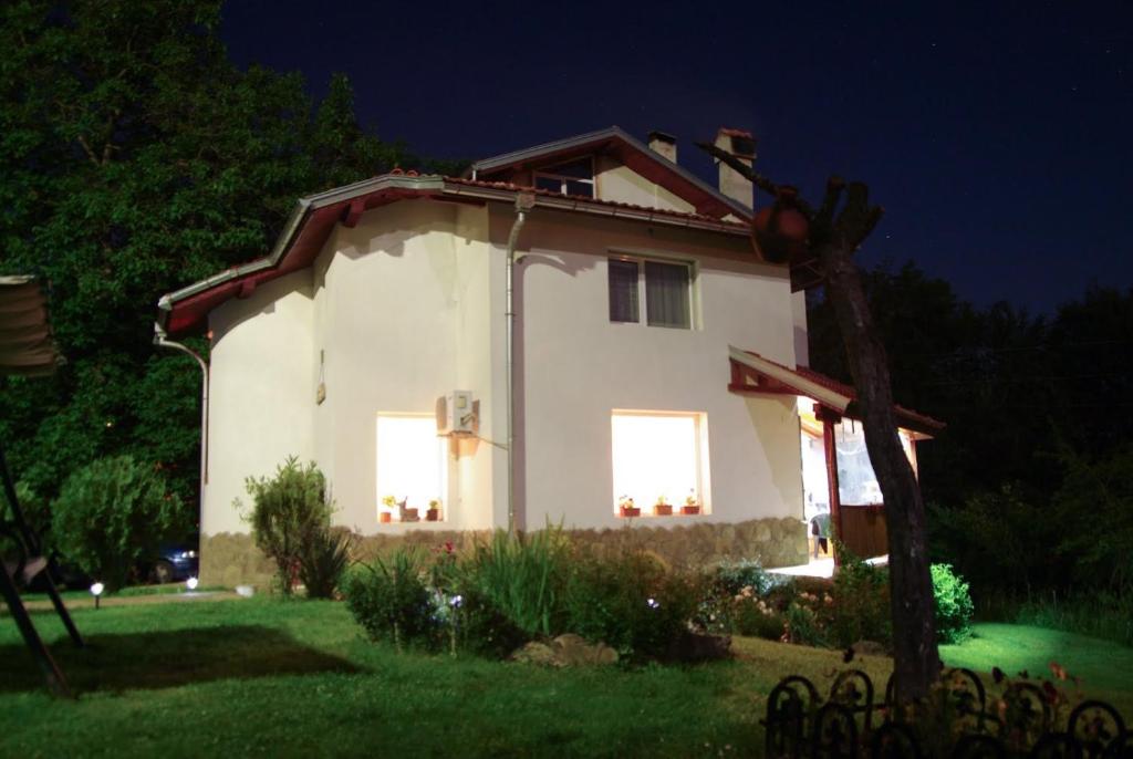 阿普里尔齐Villa Diva的一间白色的小房子,晚上有两扇窗户