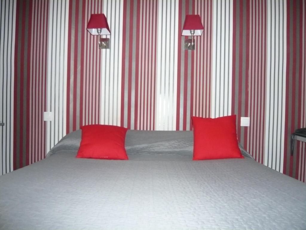 布鲁瓦圣雅克餐厅 - 酒店的一间卧室配有一张带两个红色枕头的床
