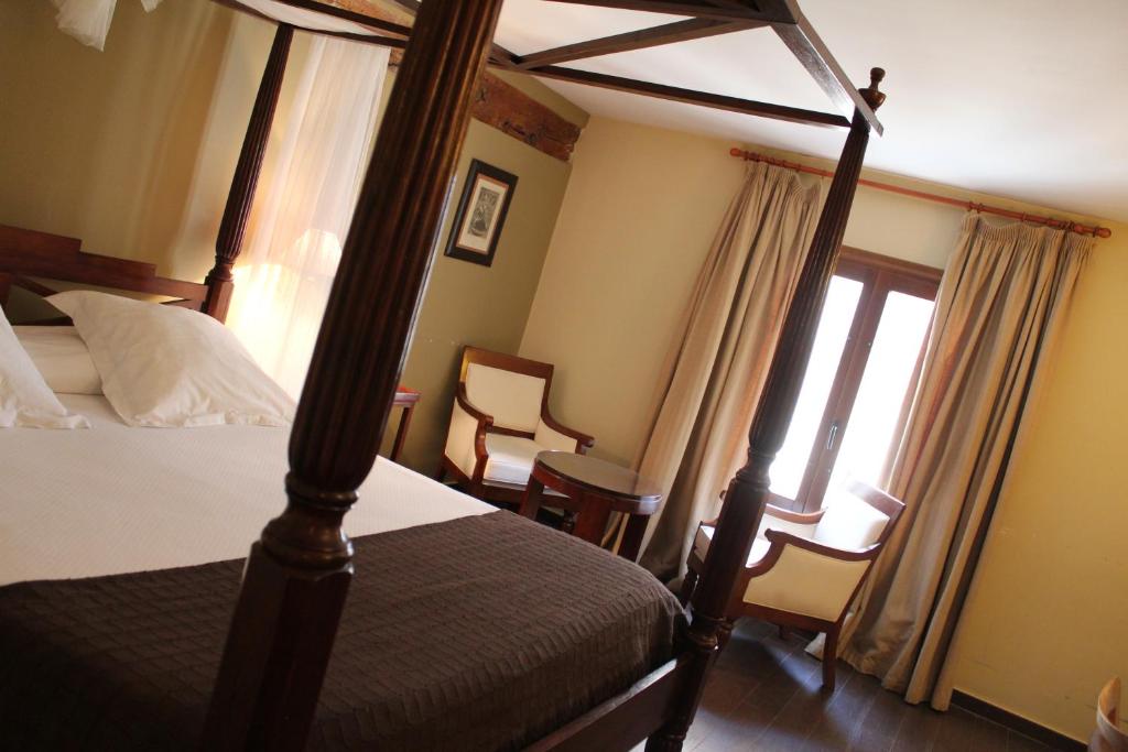 昆卡昆卡酒店的一间卧室设有四柱床和窗户。