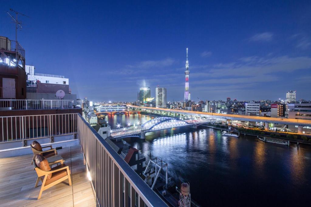 东京HOTEL AMANEK Asakusa Ekimae的享有夜间河景的阳台
