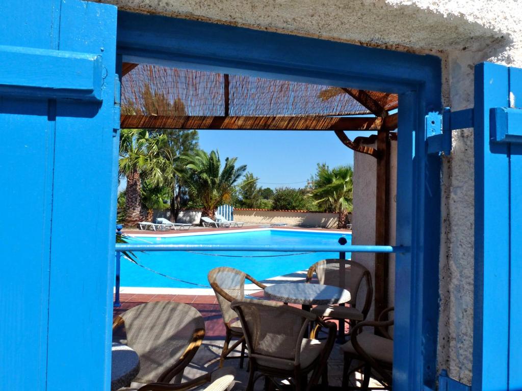 SígrionOrama Hotel的通往带桌椅的庭院的蓝色门