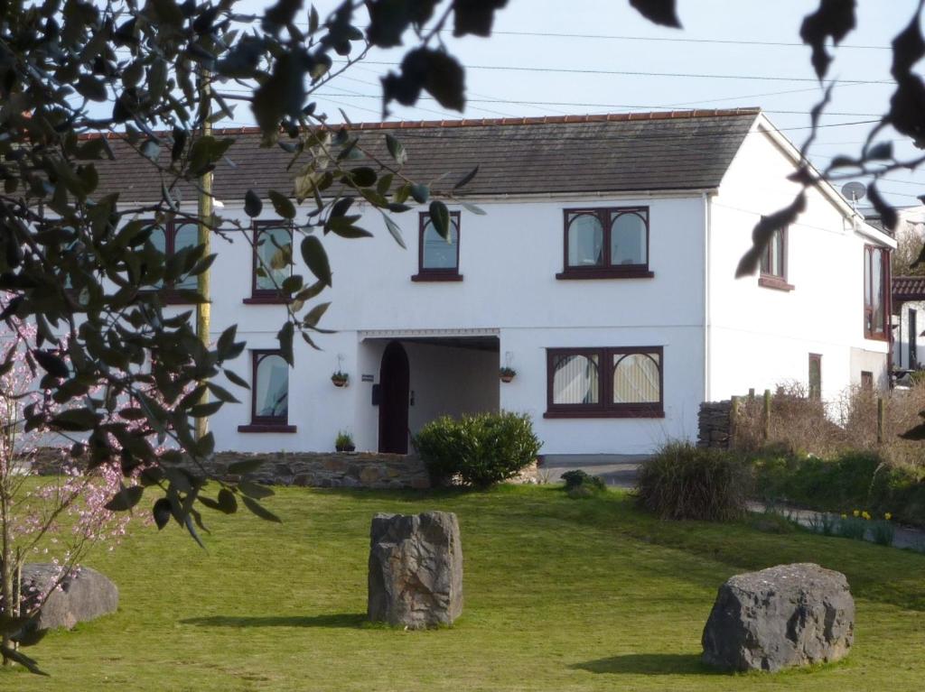 斯旺西Banfield Lodge for Gower的前面有岩石的白色房子