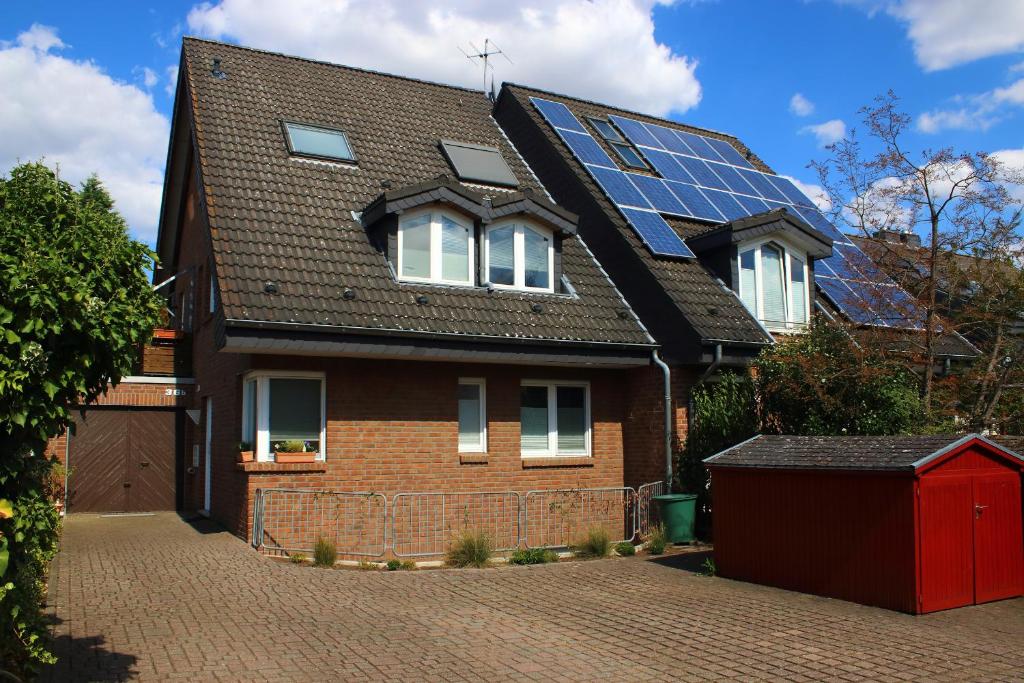 诺伊斯Apartment Am Mühlenbusch的屋顶上有很多太阳能电池板的房子