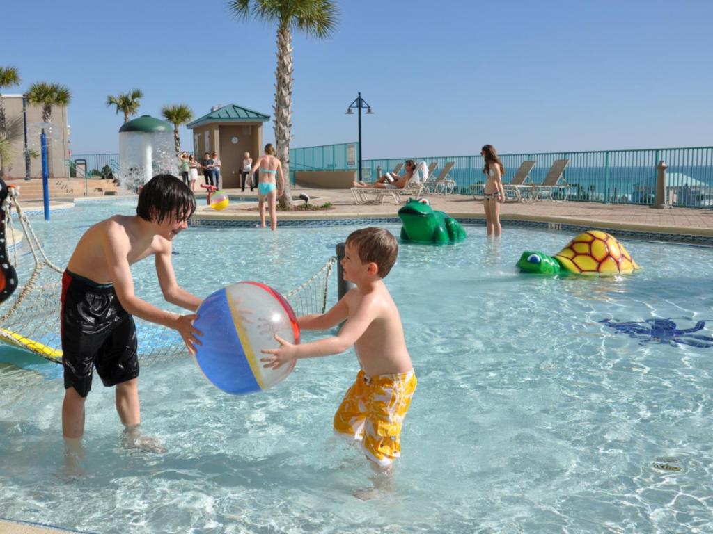 巴拿马城海滩LAKETOWN 5 POOLs STEPS TO BEACH FAMILY FRIENDLY的两个男孩在游泳池玩球