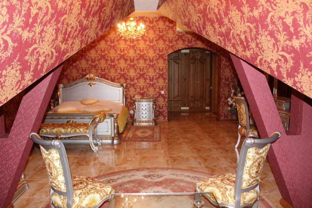 尼古拉耶夫Ceasar的一间卧室配有一张床和两把椅子