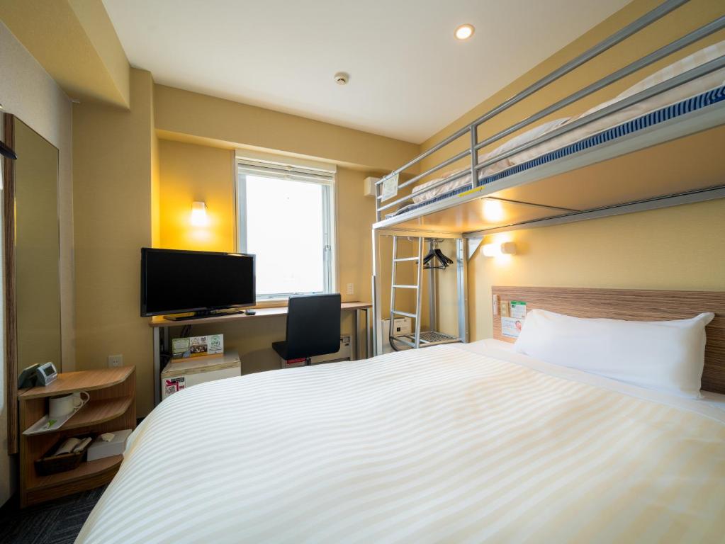 弘前市Super Hotel Hirosaki的一间卧室配有一张床和一张双层床。
