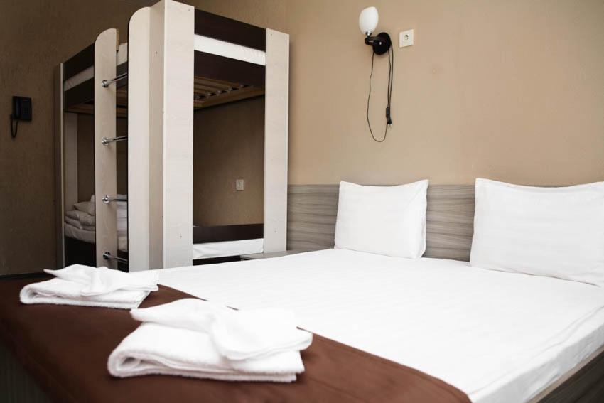 喀山加加恩旅馆酒店的卧室配有带毛巾的大型白色床