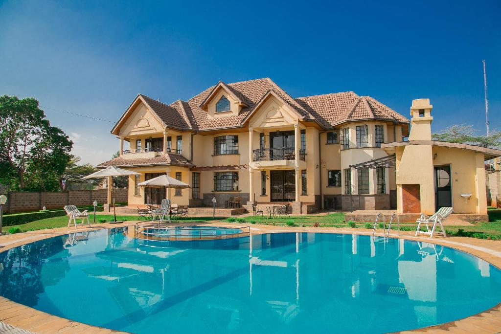 内罗毕吉吉里兰花屋住宿加早餐旅馆的一座大房子,前面设有一个游泳池