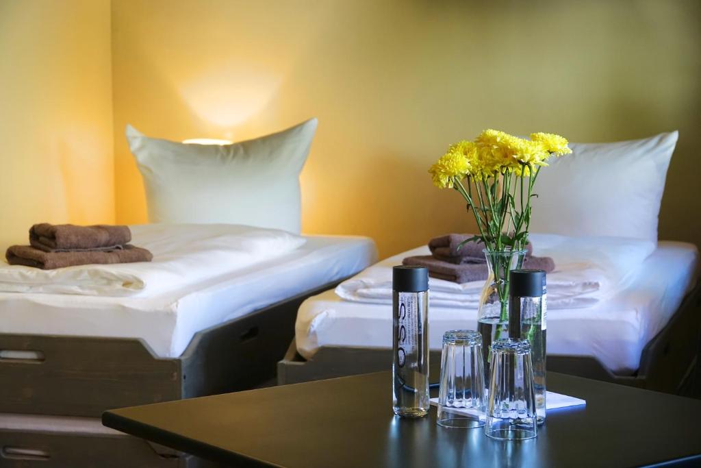 奎德林堡Hostel & Hotel Samocca的一间设有两张床和一张鲜花桌的房间