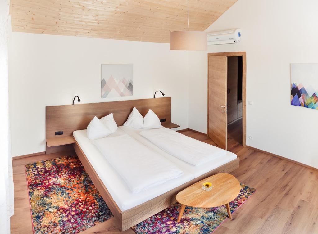 毛特恩艾德维尼斯加特豪斯尼科来霍夫加尔尼酒店的卧室配有一张白色大床和木制床头板