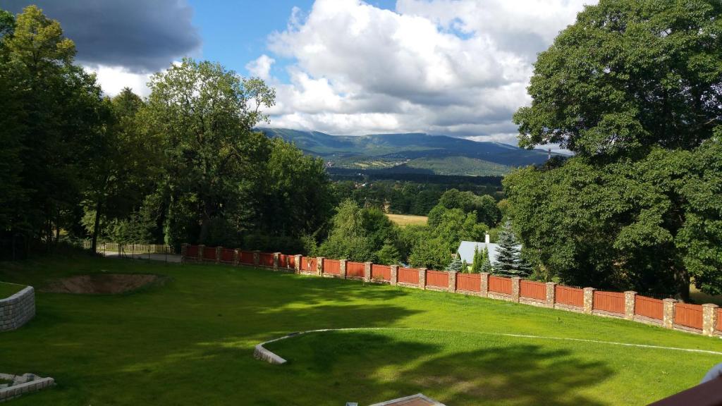 BukowiecSarna Karkonosze的绿色庭院,有栅栏和山脉背景