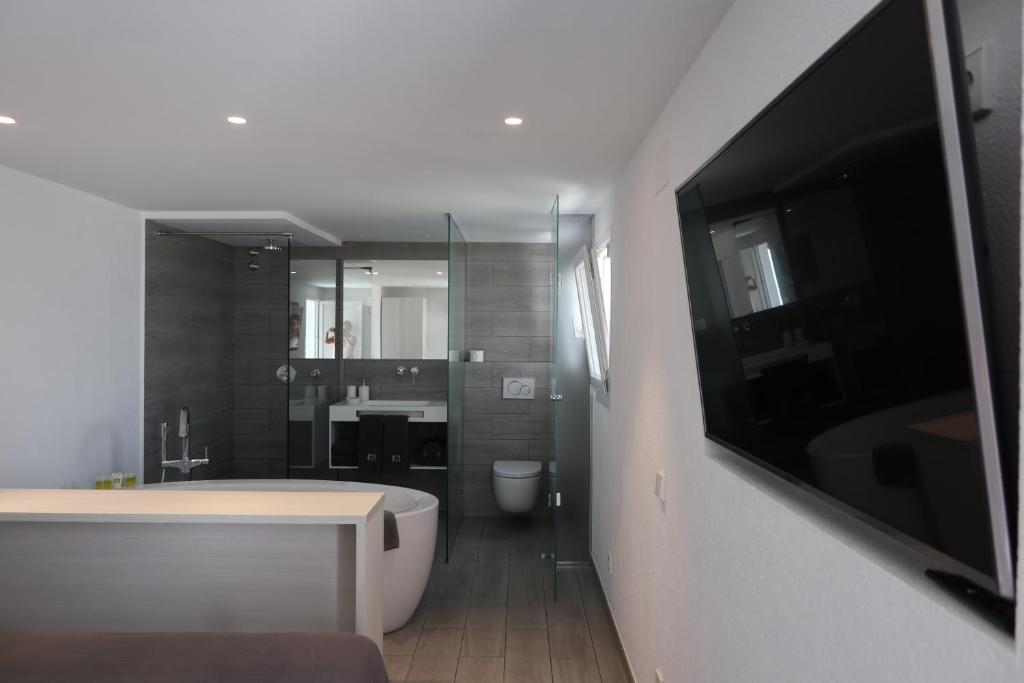卡达克斯卡帕蒂姆卡达克斯酒店的带浴缸的浴室和墙上的电视