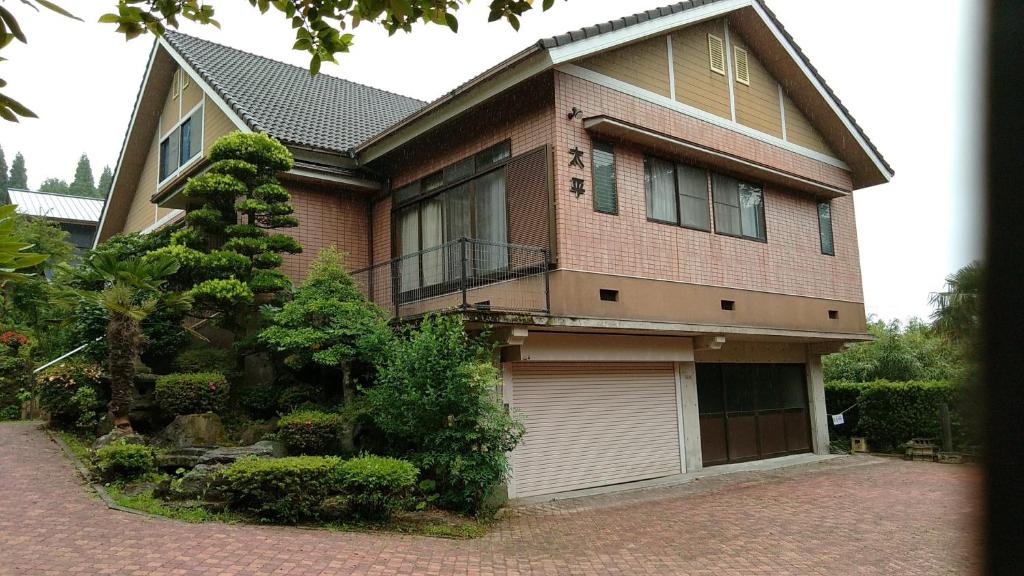 阿苏市Guesthouse Taihei的一座带车库的大型砖屋