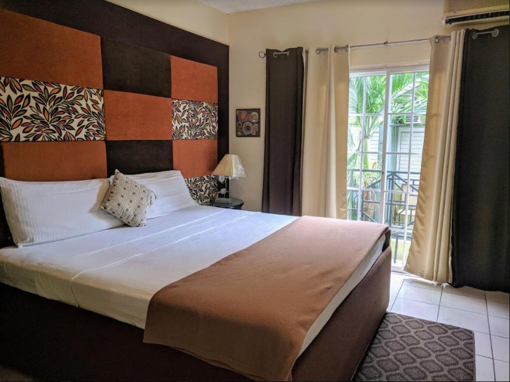 金斯敦克里斯塔尔别墅酒店的一间卧室设有一张大床和一个窗户。