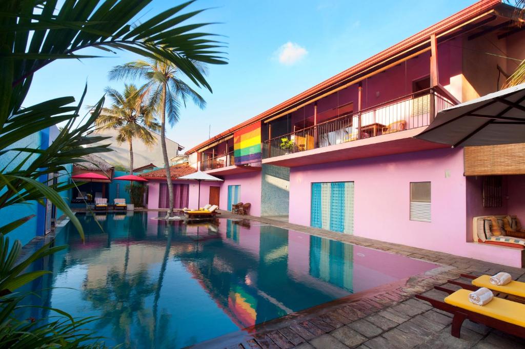 尼甘布迪克曼度假村“精品酒店”的一座带度假村的建筑前的游泳池