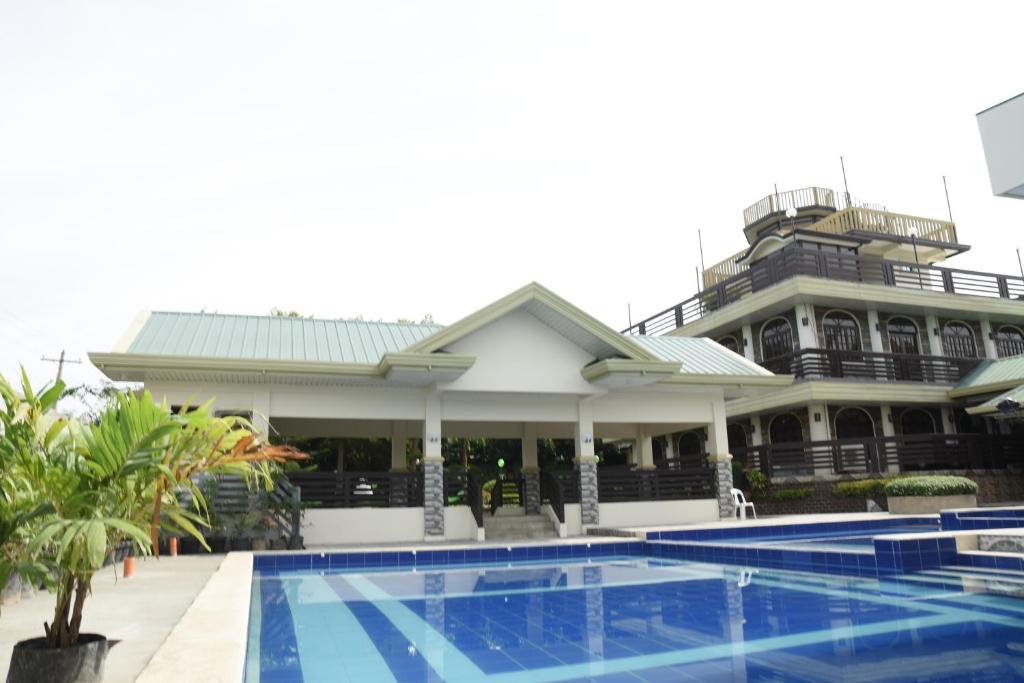 Palayan CityVilla Esmeralda Bryan's Resort Hotel and Restaurant的大楼前设有游泳池的酒店