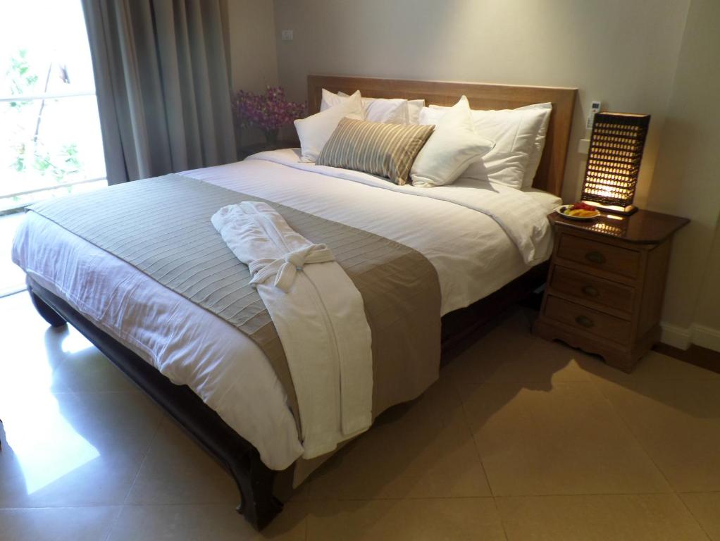 南芭堤雅韦斯特伯里公寓酒店的一间卧室配有一张大床和床头柜