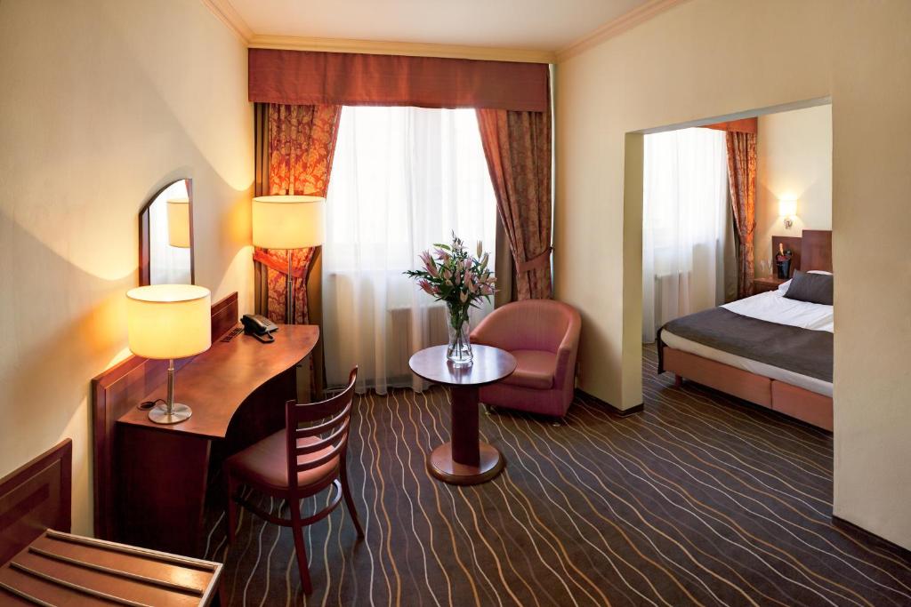 布拉格Luxury Family Hotel Bílá Labuť的酒店客房设有一间带一张床和镜子的卧室